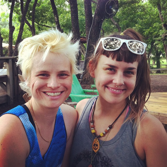 two girls wearing sunglasses with the middle finger of their mouth