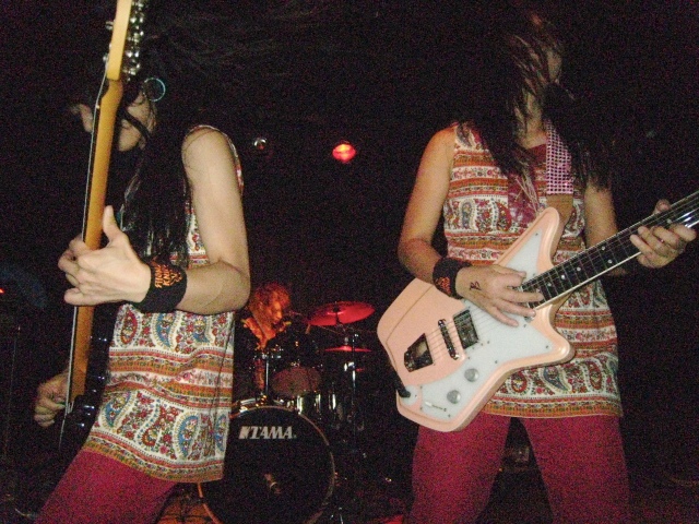 two girls are playing guitars on the stage