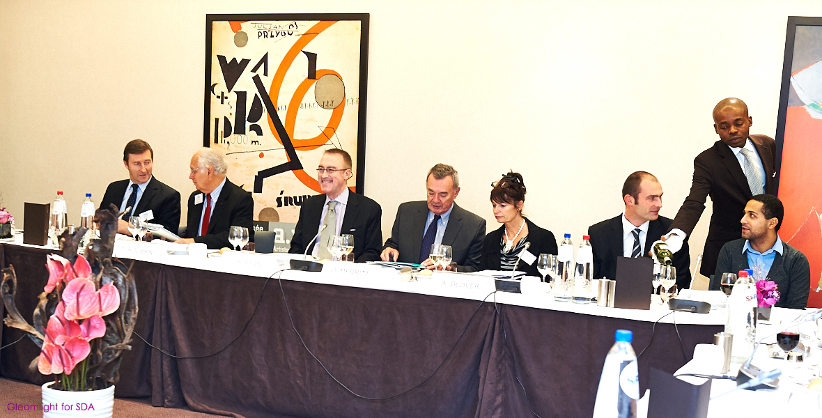 several men in suits are sitting at a long table