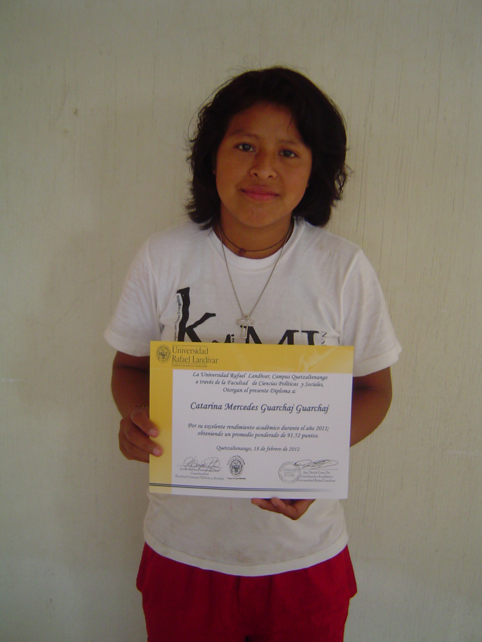 a boy is holding up a paper with the certificate on it
