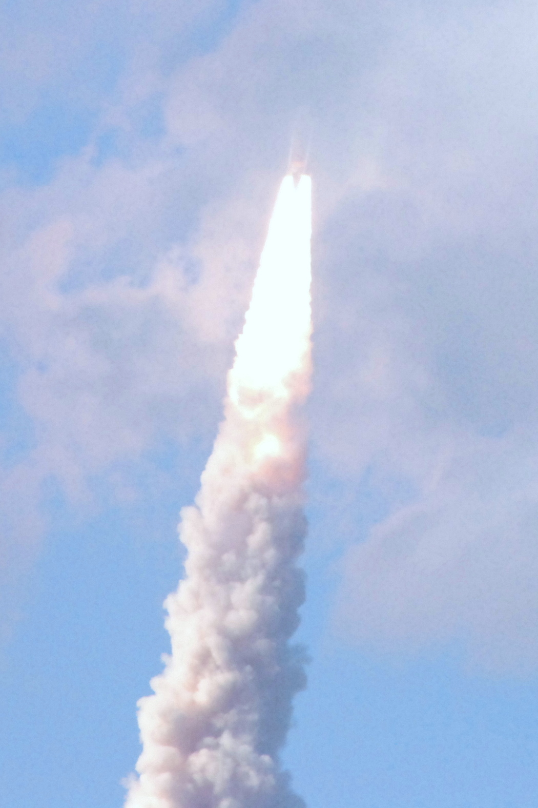 a large white cloud is pouring smoke into the air