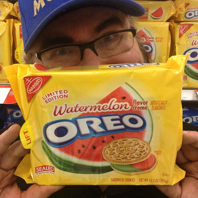 the man is holding up a box of oreo