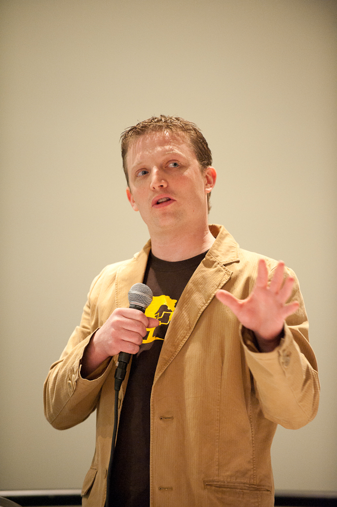 the man is speaking into his microphone at a presentation