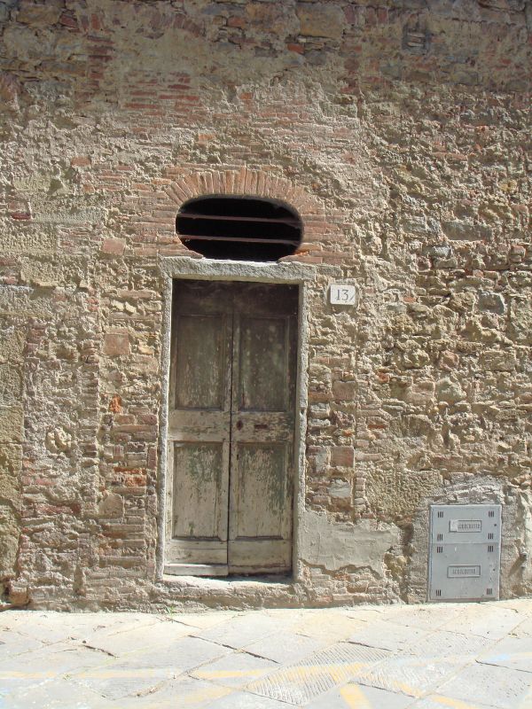 a door is opened on an old brick wall