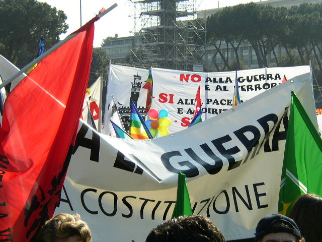 a crowd of people standing in a line with banners