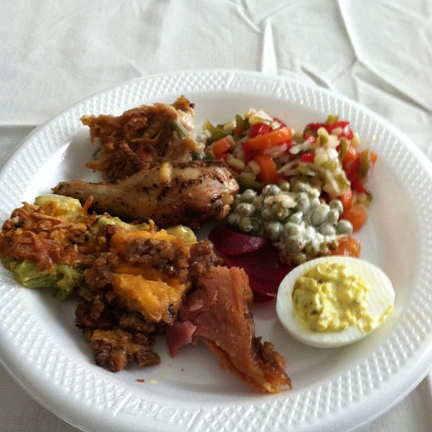 a plate with a meat, vegetables and some fruit