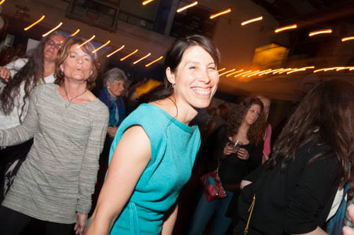 a woman standing on the side of a dance floor