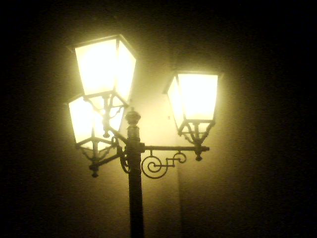 a street light on a pole in a dark room