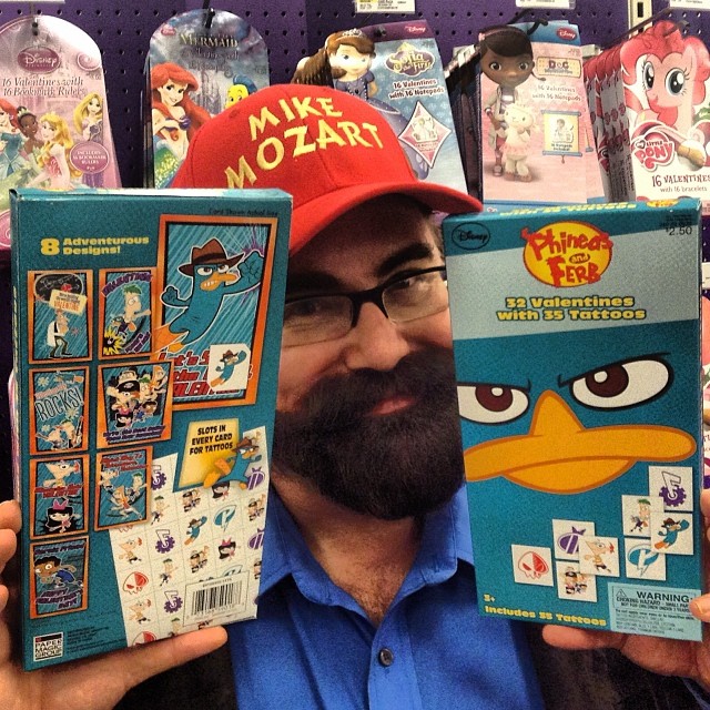 a man holding up a box of sesame the bird toy