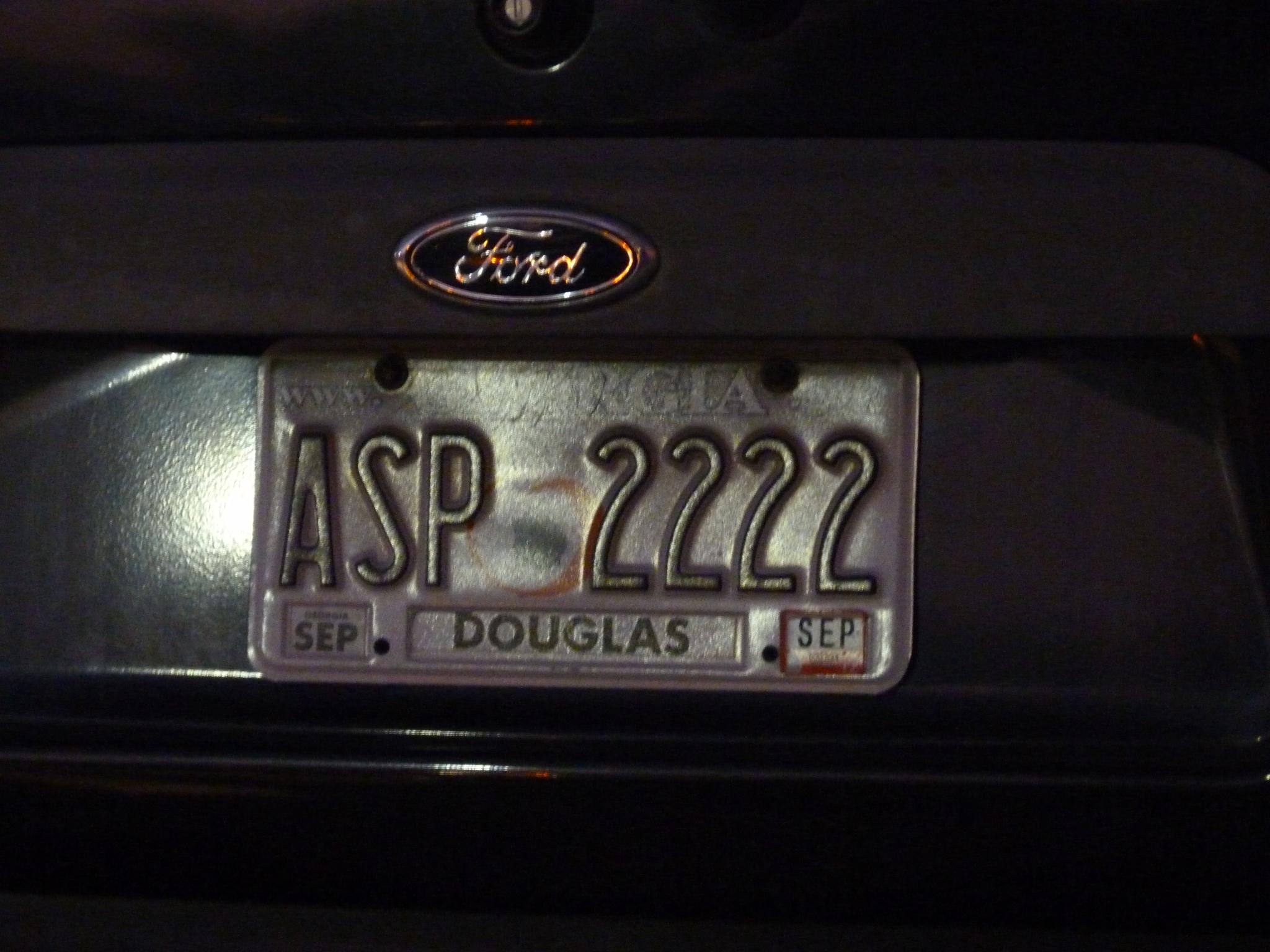 a license plate is displayed for a man on the phone