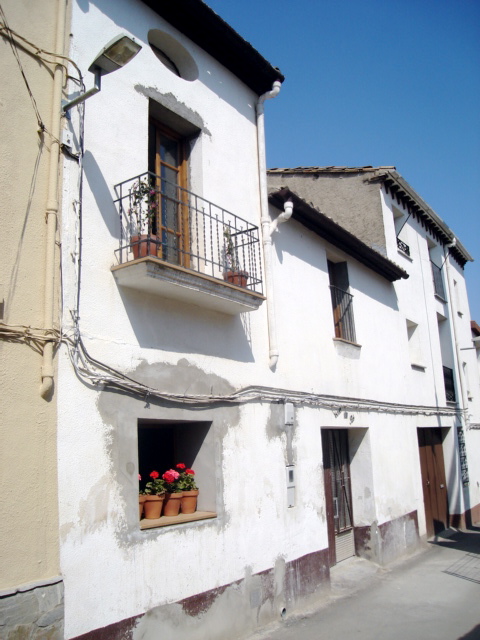 a white building with a balcony and flower box in it