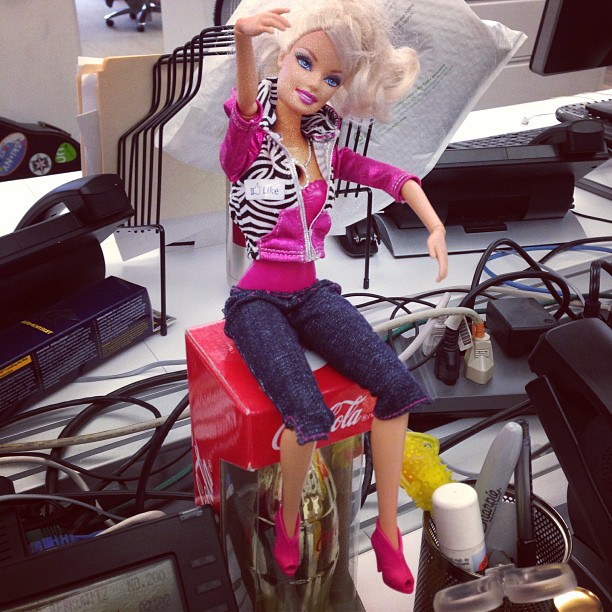a barbie doll in front of several computer equipment