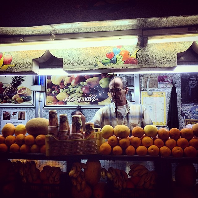 an old man is shopping in front of some fruit