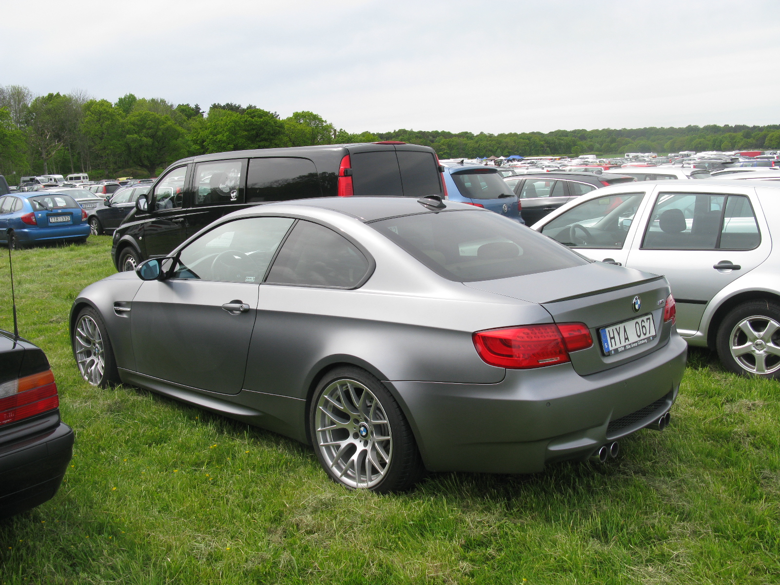 two silver cars that are sitting in the grass