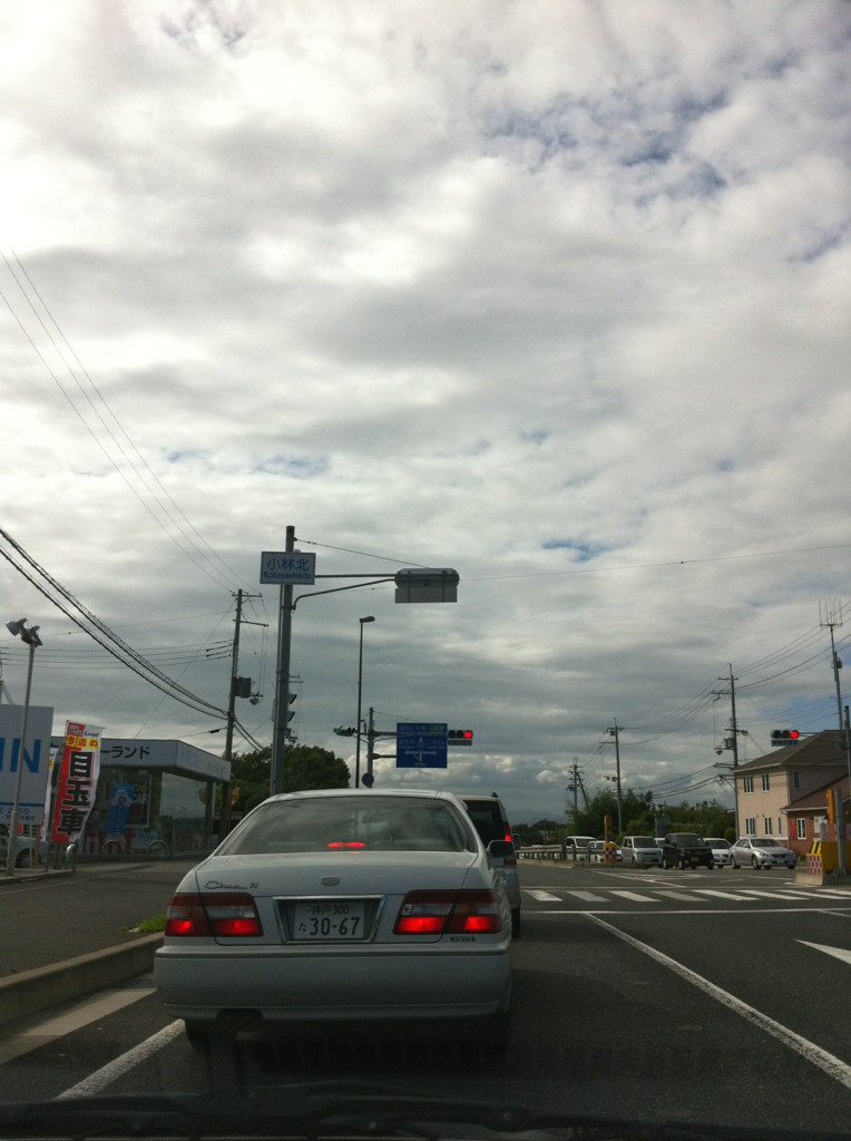 the light shines red in the background as cars wait at an intersection