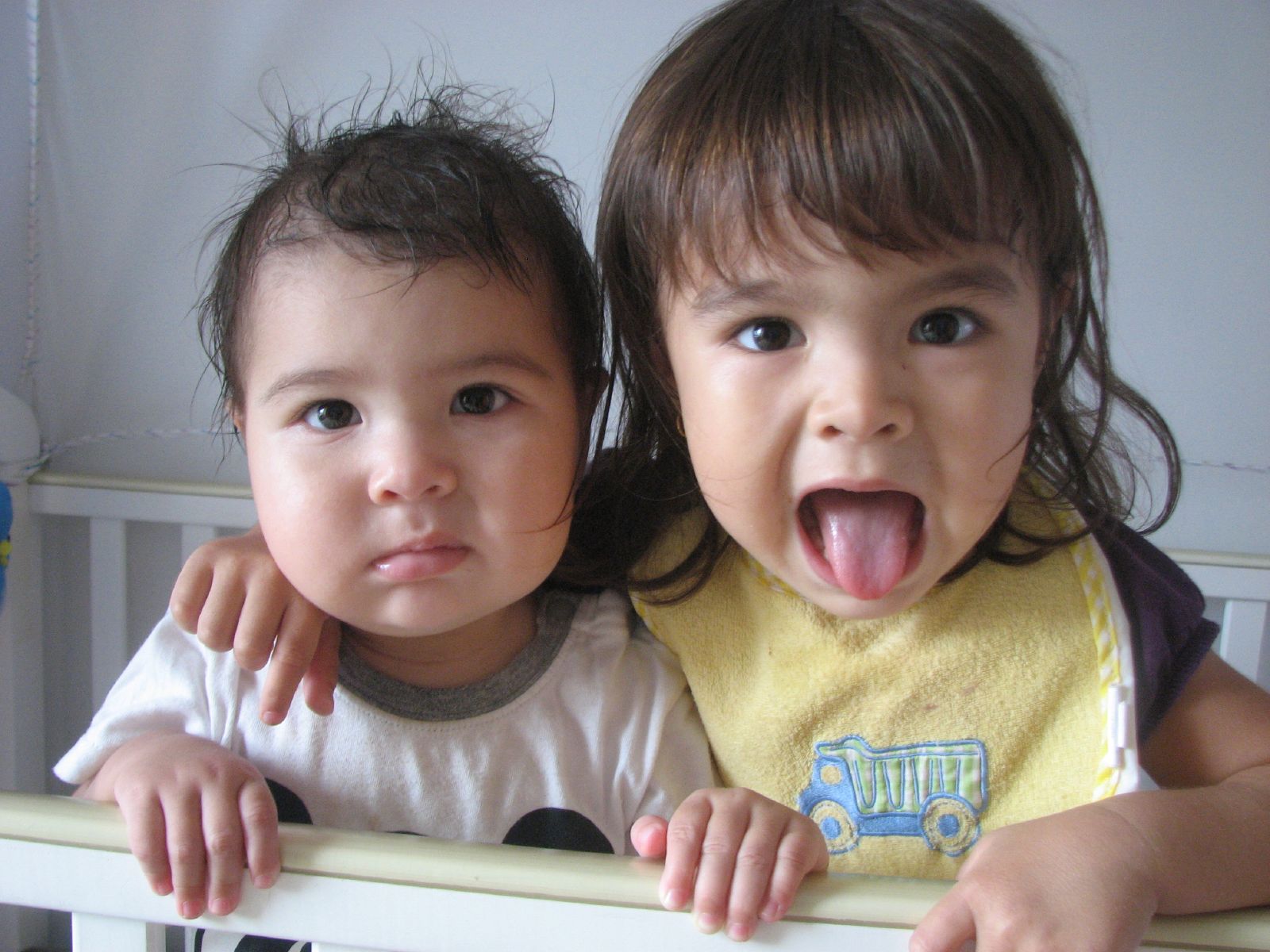 two small children posing on a bed with their mouths open