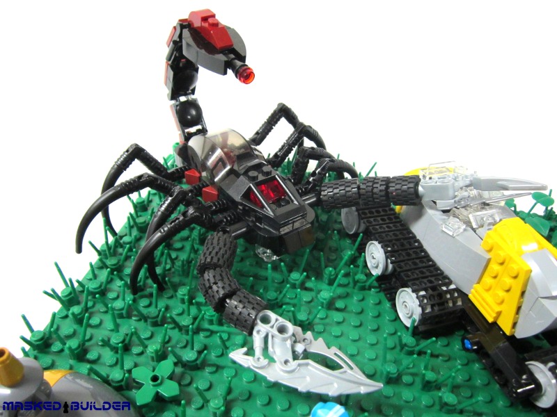 a lego spider and a lego car in the grass