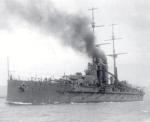 this is a large battleship in the water with steam billowing from its stacks