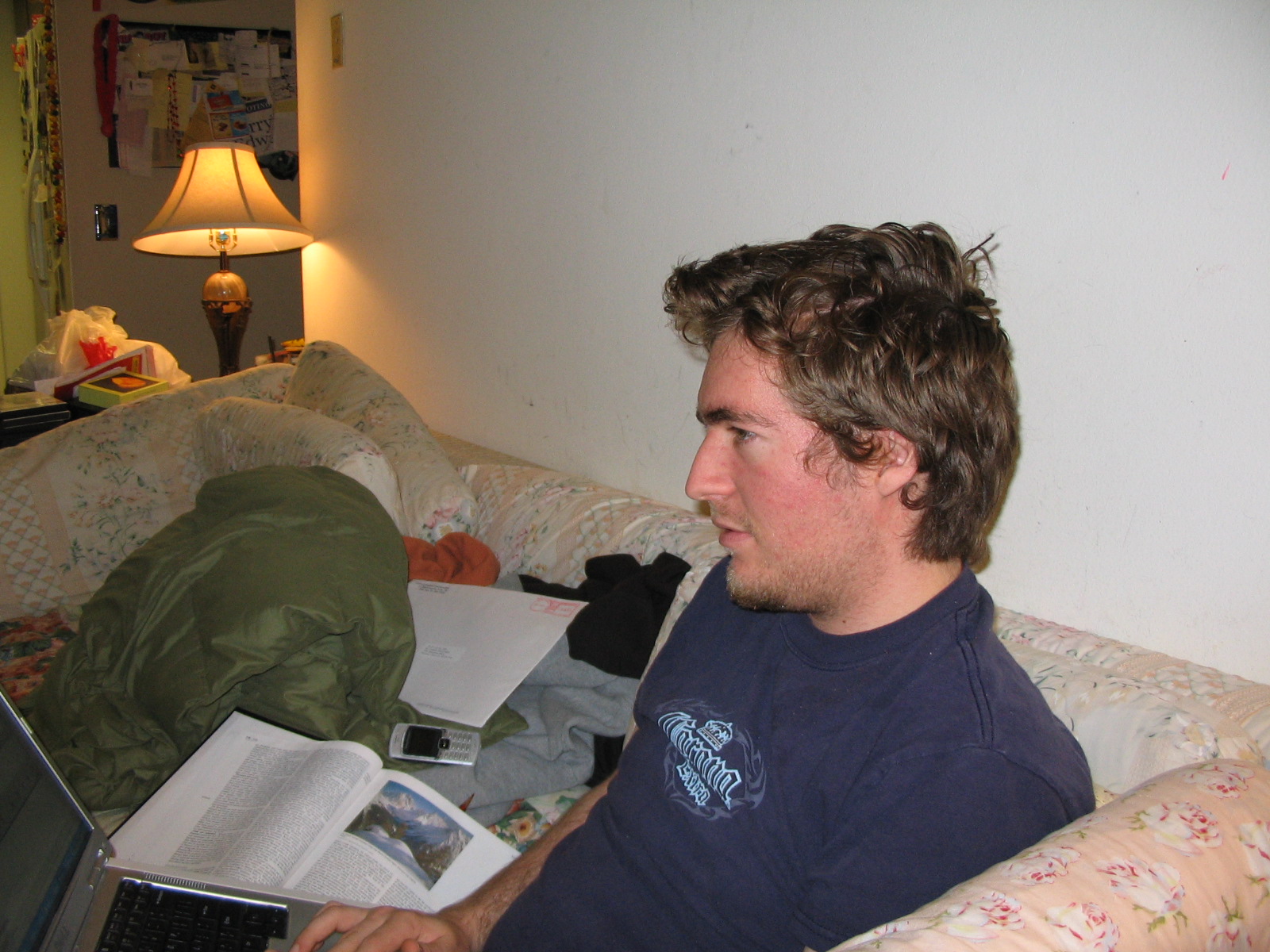 a man is sitting on the couch and looking into his laptop