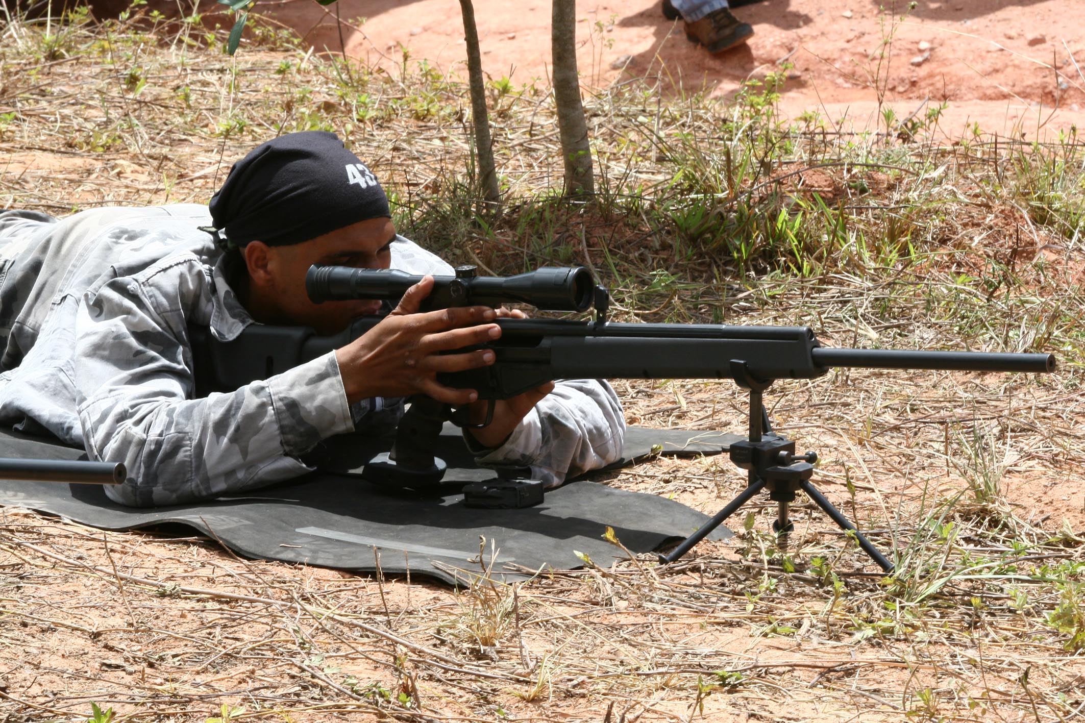 a man laying on the ground with his gun in hand