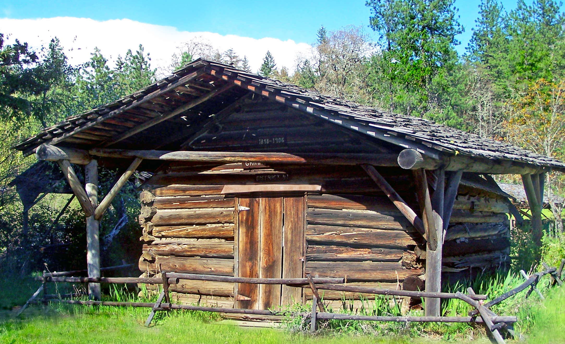 an old log cabin in the middle of a forest