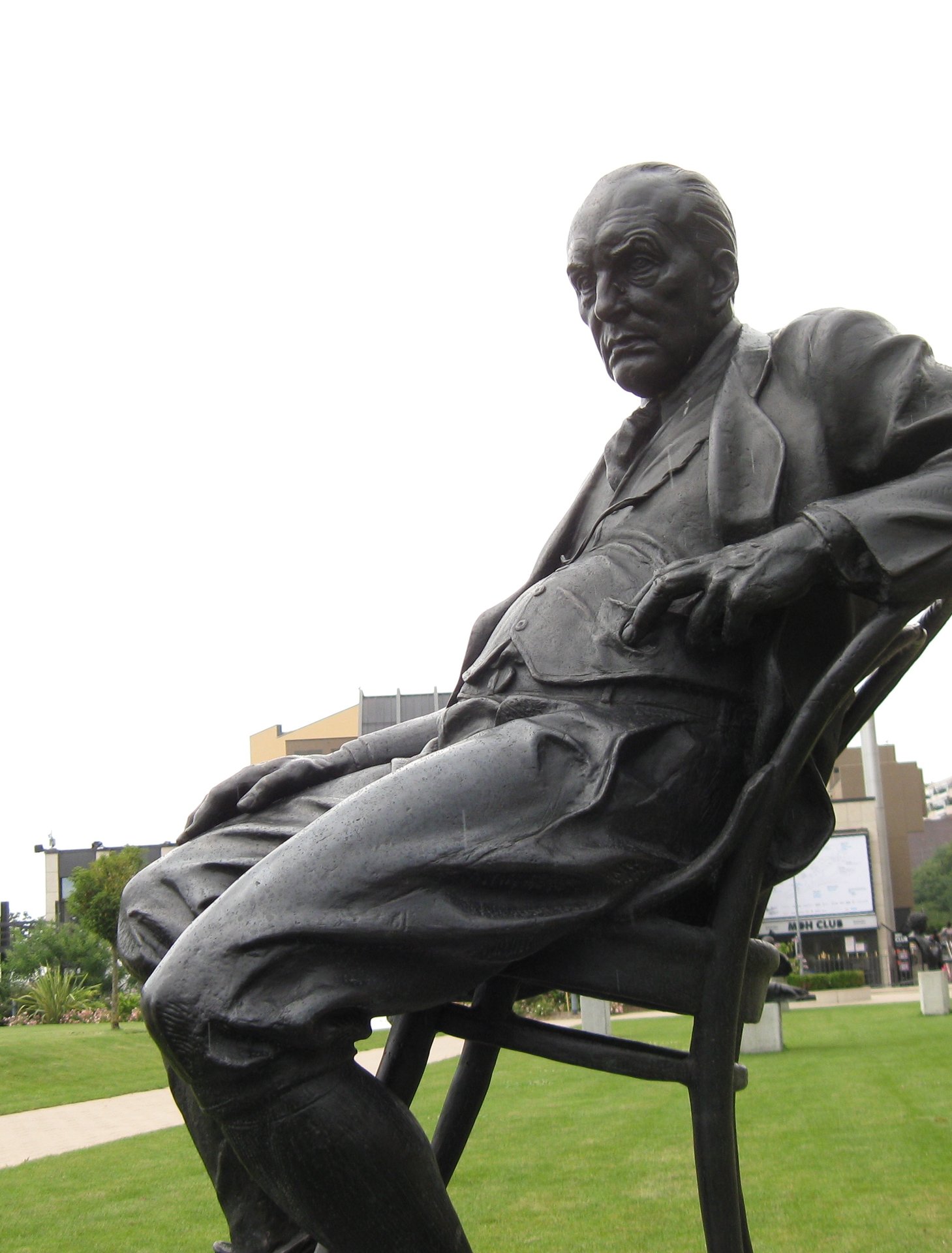 a statue of a man sitting on top of a chair