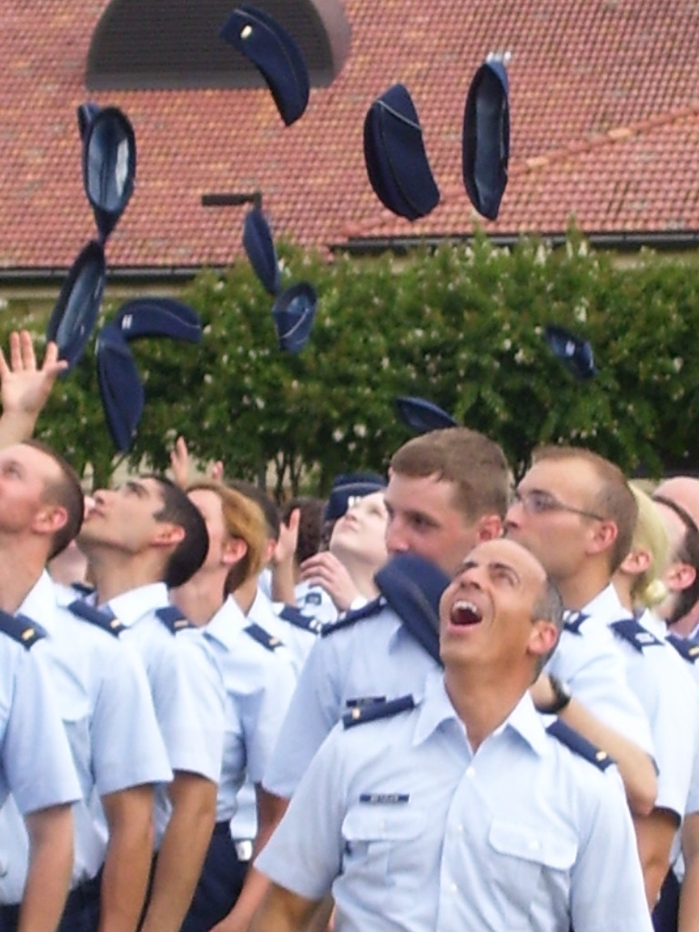 men singing with graduation caps flying in the air