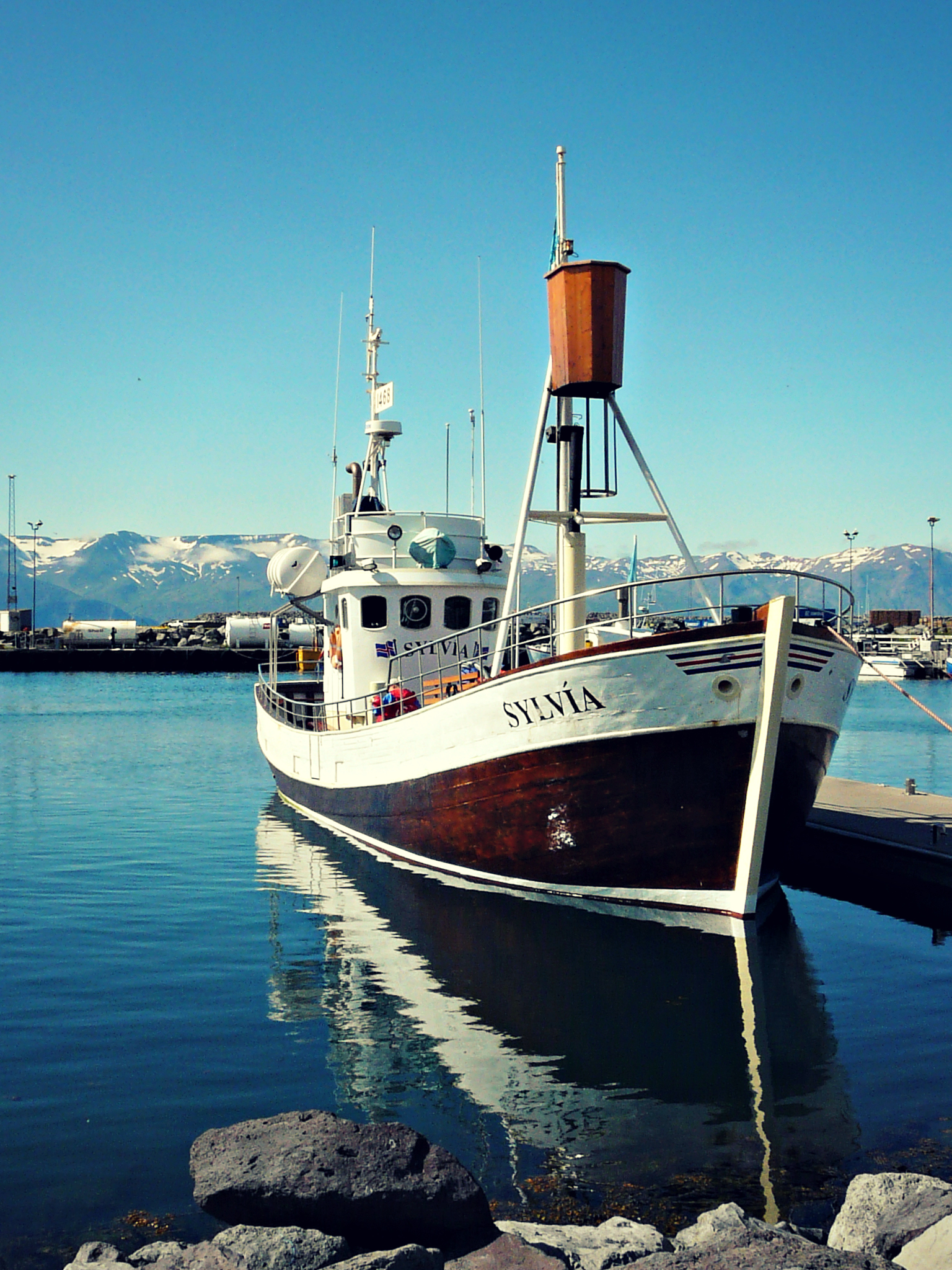 a boat is parked in the water beside the dock