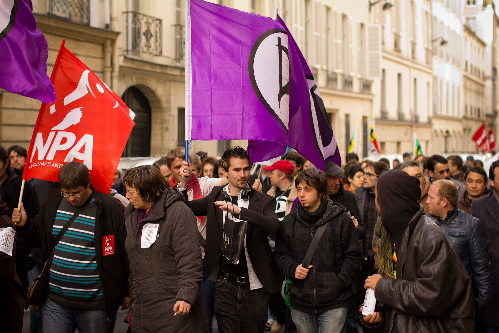 an urban area with a lot of people and colorful flags