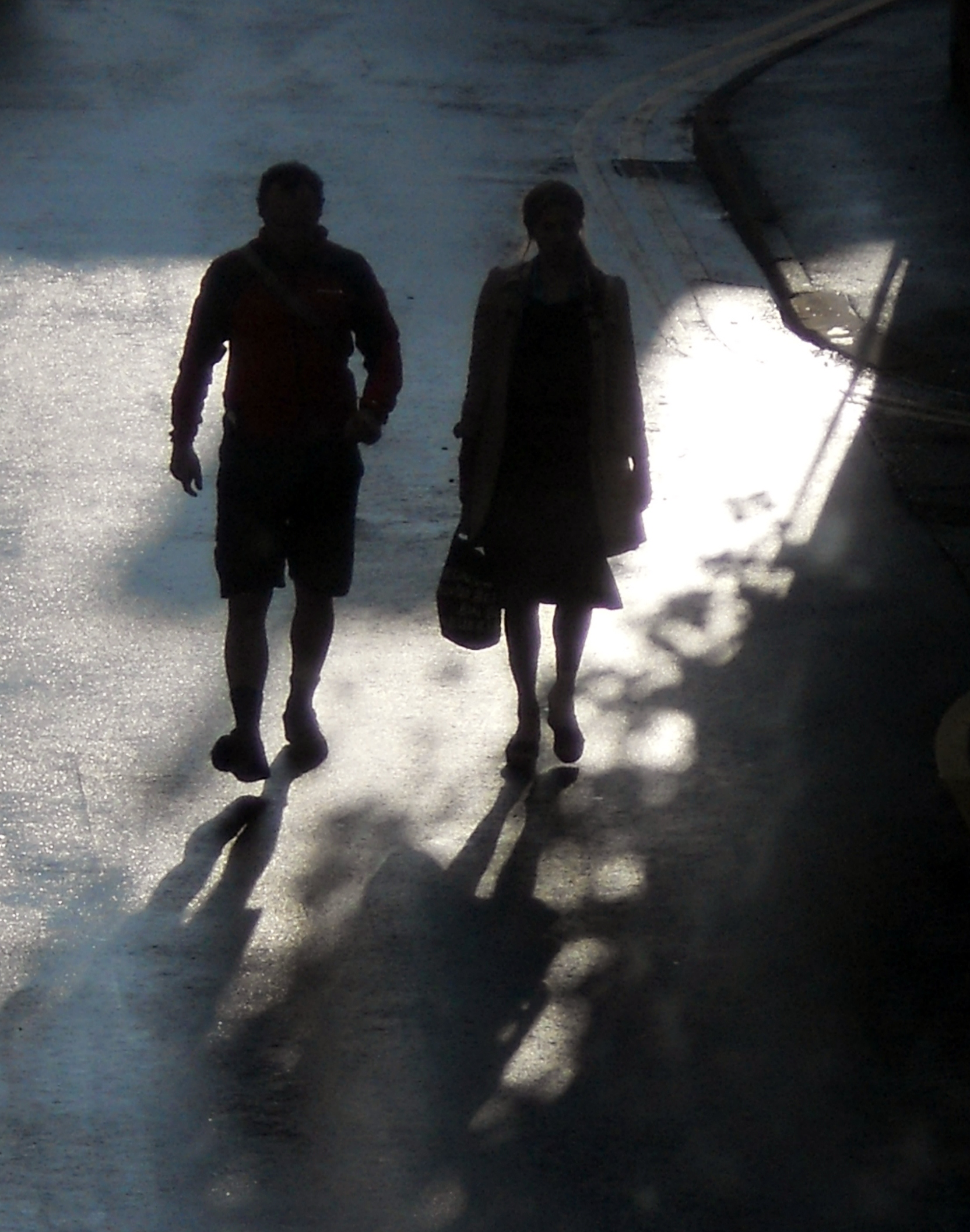 a couple walking down a sidewalk in winter