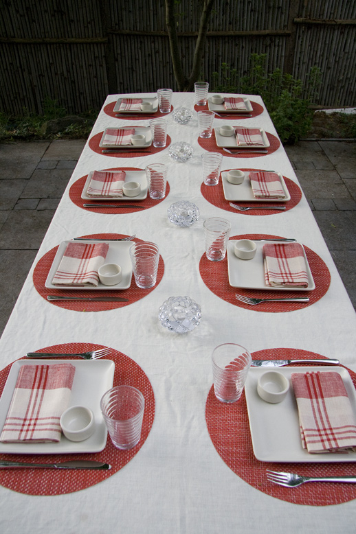 a table is set with plates and place mats for a festive dinner