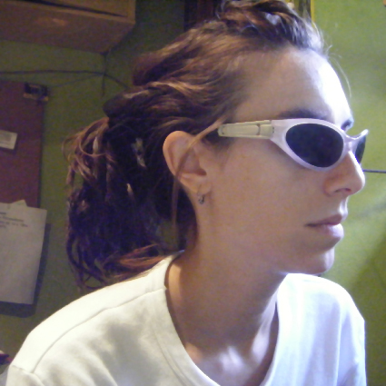 a girl with sunglasses on and a cell phone in her hand