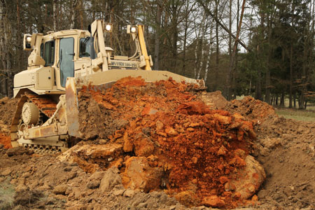 a bulldozer digging around a pile of dirt