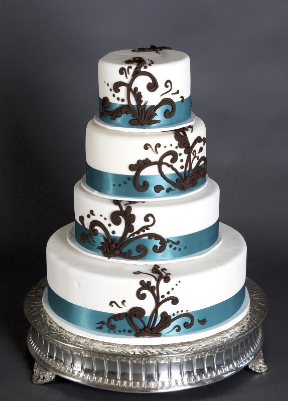 a large four tier cake with silver trim