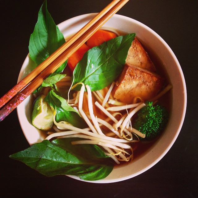 there is a bowl of ramen with greens