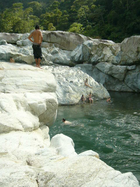 people swimming in an almost rocky pool