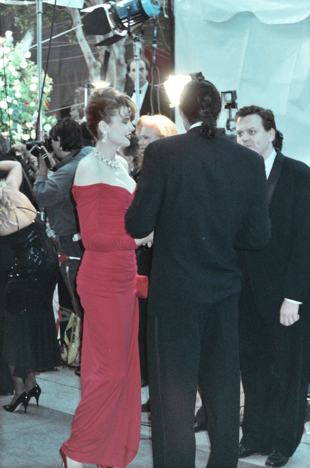 a woman in a red gown standing next to a man