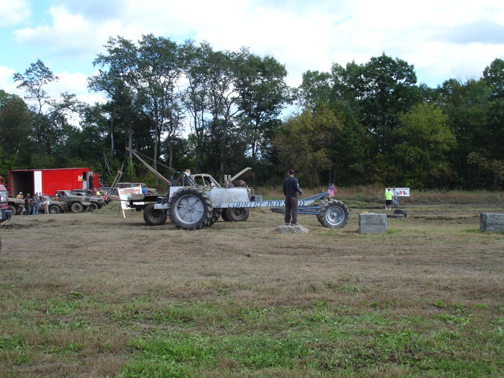a field with several tractors, people and an object
