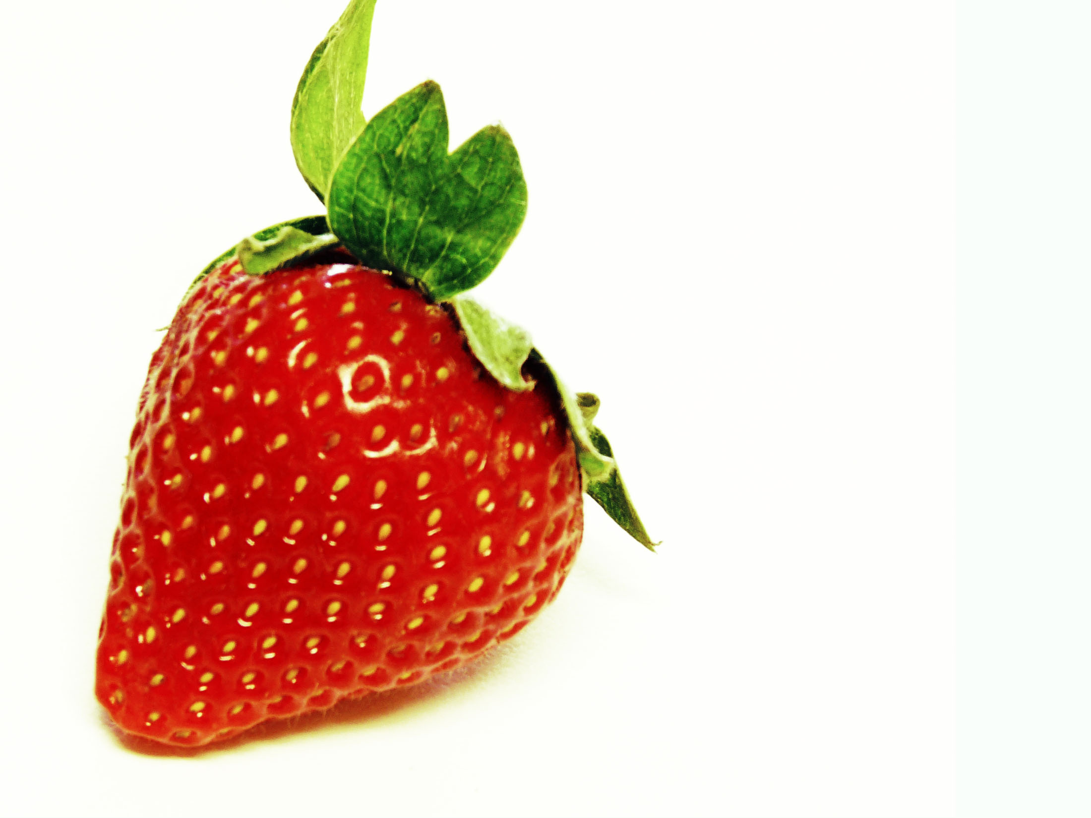 an image of a large strawberry with the leaves still attached