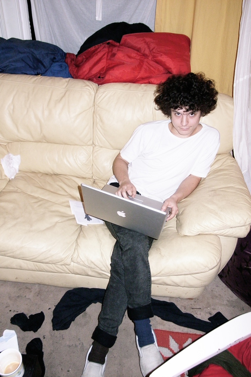 a person sits on a couch in front of a laptop