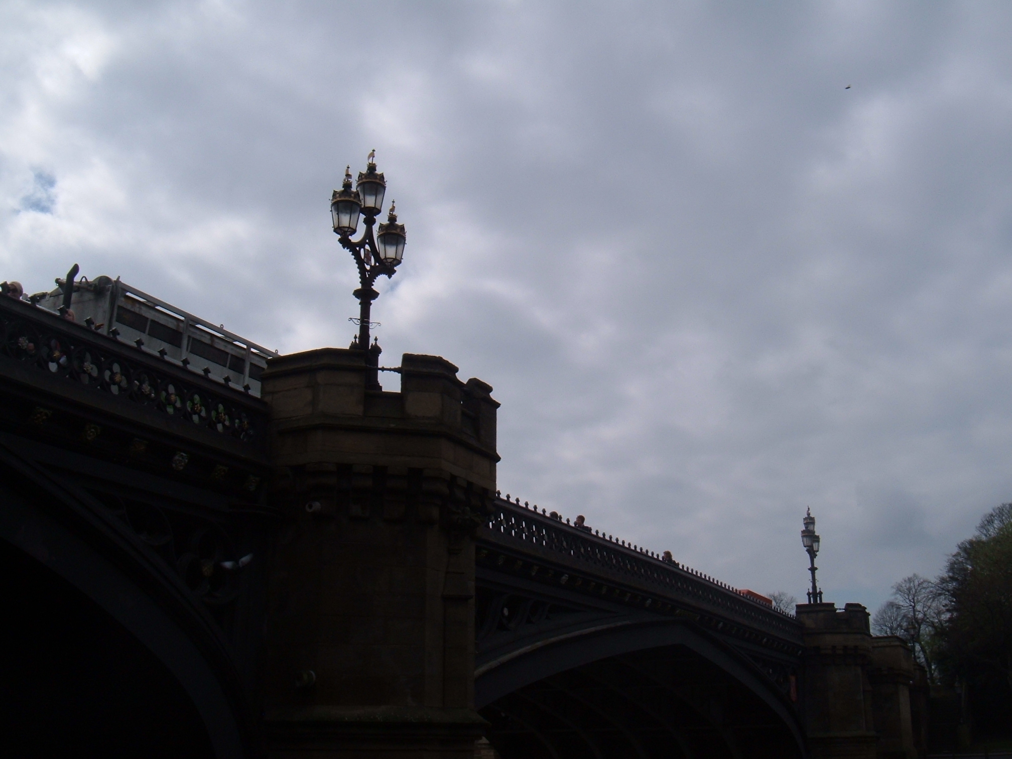 a clock on the top of a lamppost in the city
