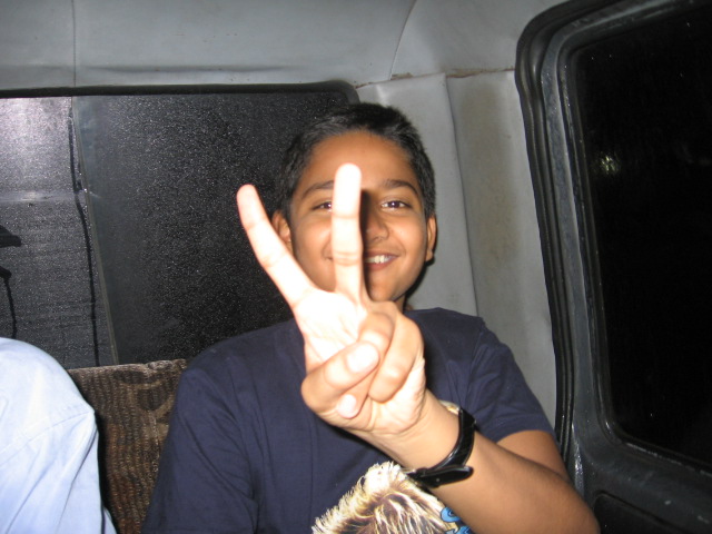 the young man smiles and gives the peace sign
