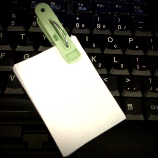 a computer keyboard with a clip on top of the paper