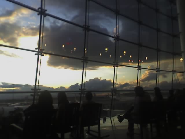 people sit in chairs looking out at an ocean and sky