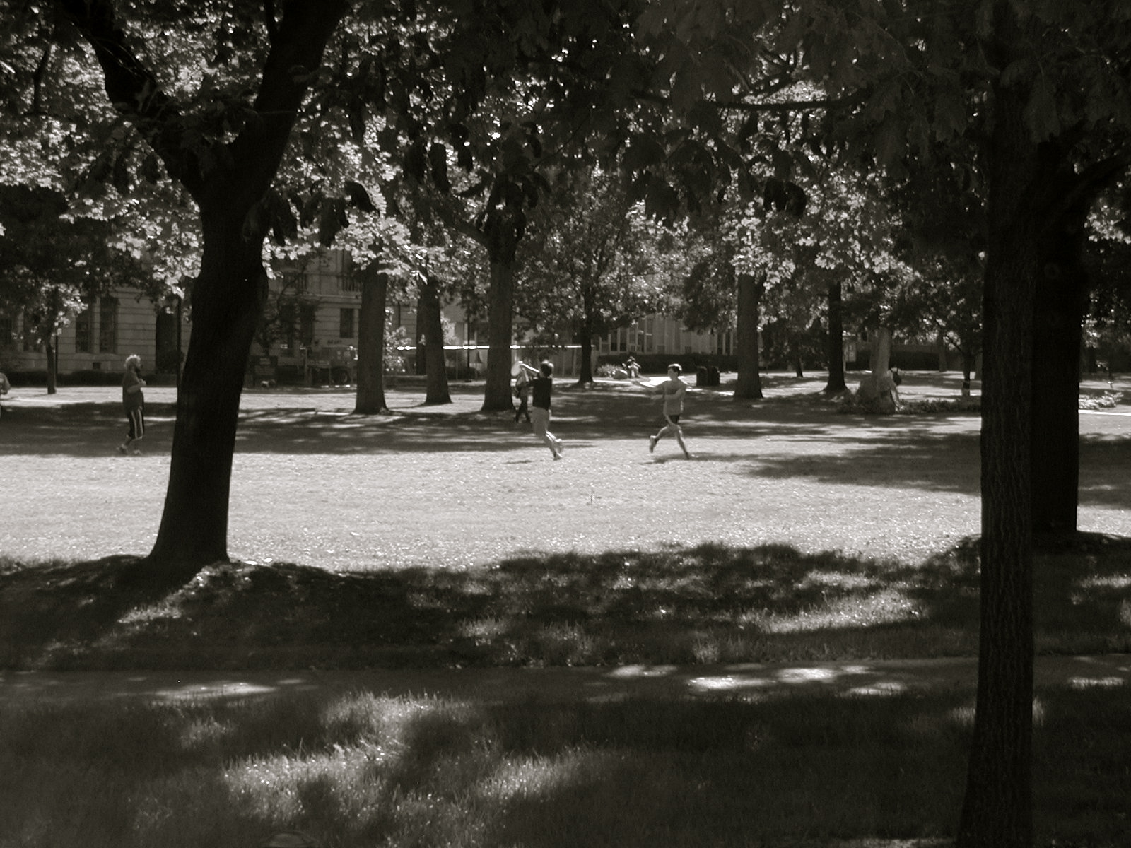 a black and white po of two people running in the grass