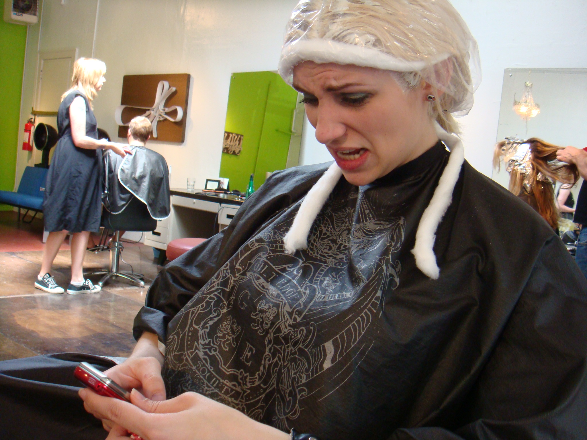 a woman is using her cell phone while at the salon