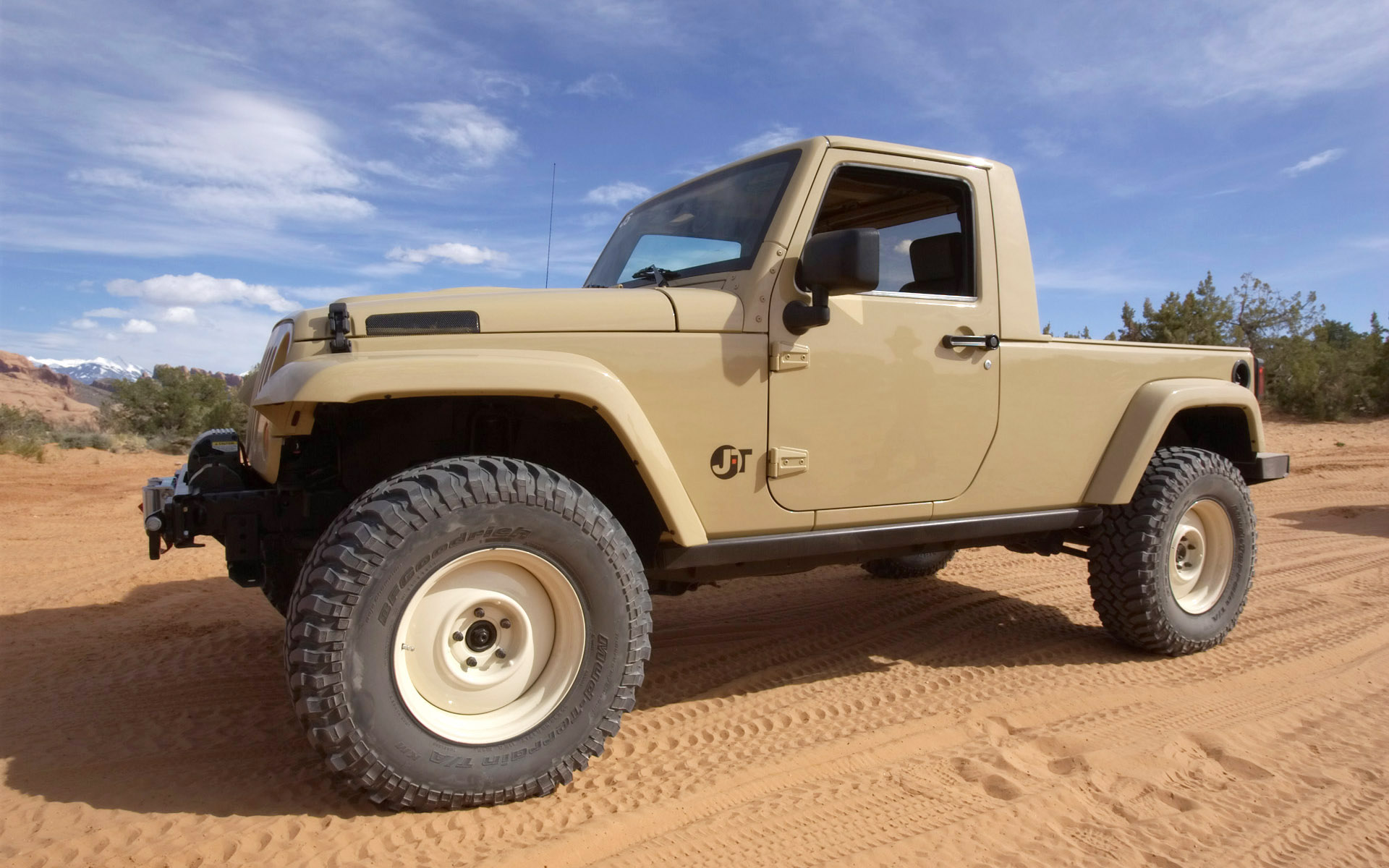 a large beige jeep driving through a desert