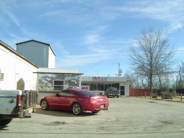 a red car parked in front of an air repair garage