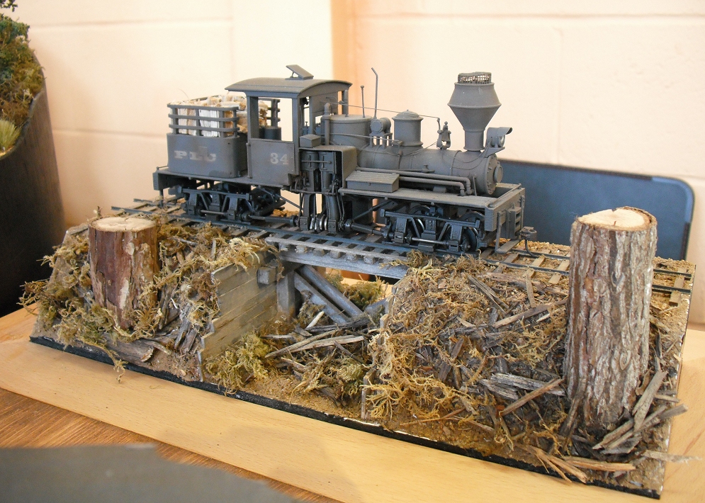 a wooden table topped with train sculptures made out of wood logs