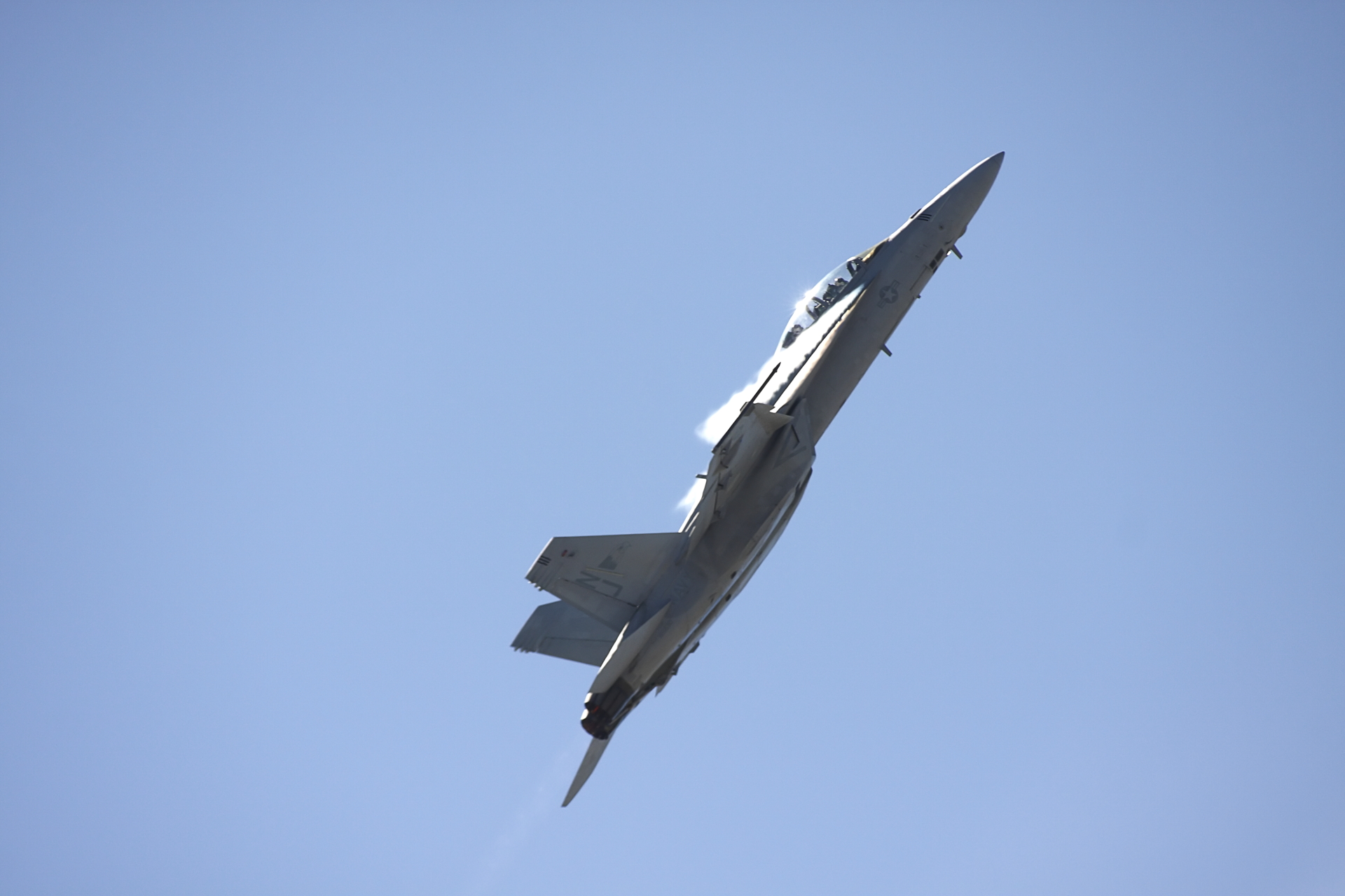 a jet fighter flying through the sky in full display